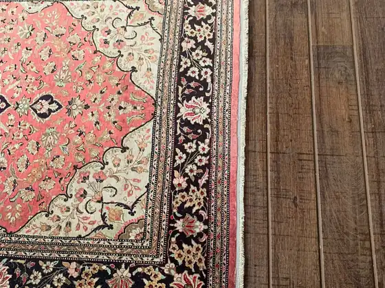 Tapis de Qom, champ ivoire et médaillon rose.