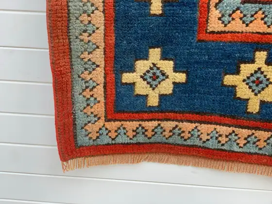 Tapis du Caucase à bordure bleue, angle et franges.