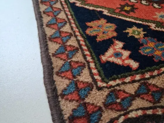 Tapis roulé sur lui-même, revers visible.